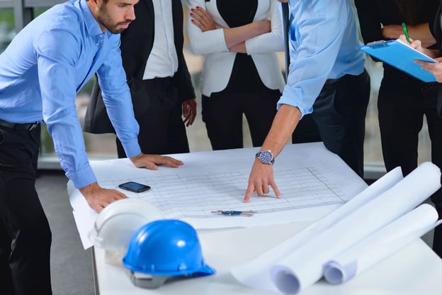 business people group on meeting and presentation  in bright modern office with construction engineer architect and worker looking building model and blueprint  plans